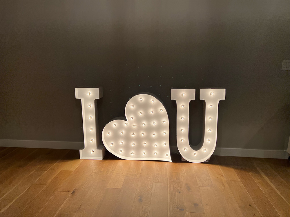 "MU" in lit marquee letters with a heart