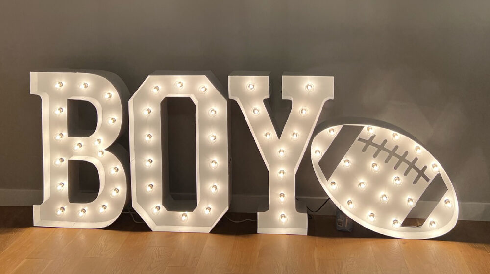 The word "Boy" in lit marquee letters with a lit football next to it