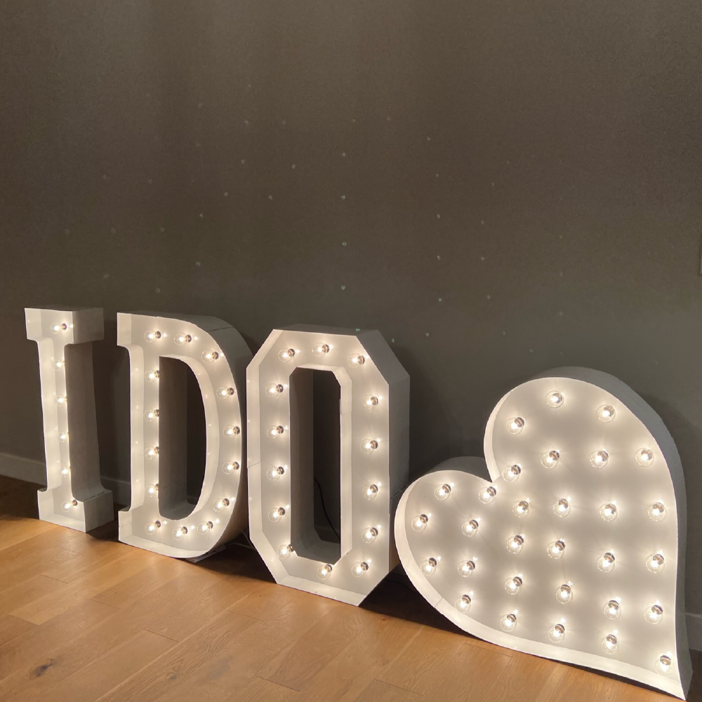 'I do' in lit marquee letters with a lit marquee heart
