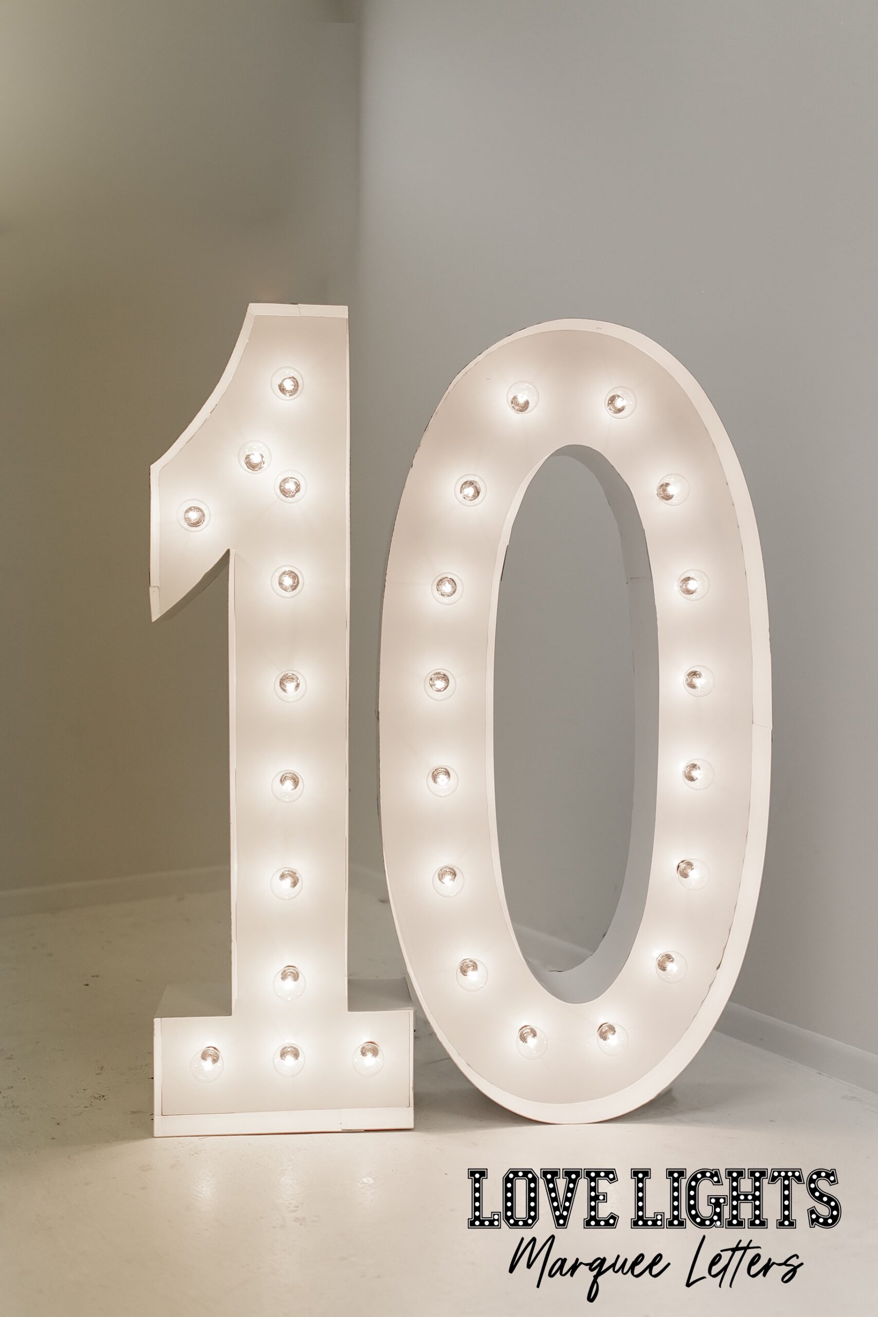 10 in lit marquee letters in a room with balloons