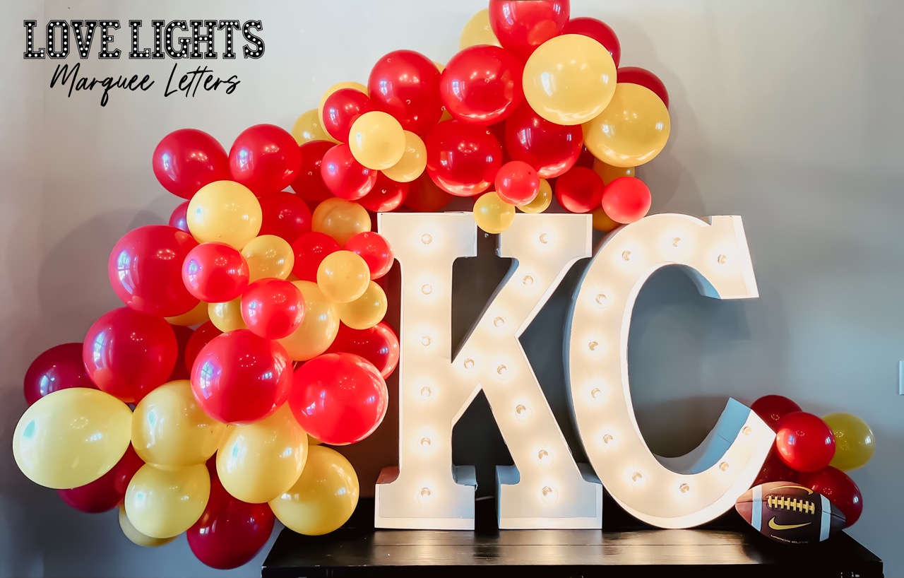 KC in lit marquee letters with balloons
