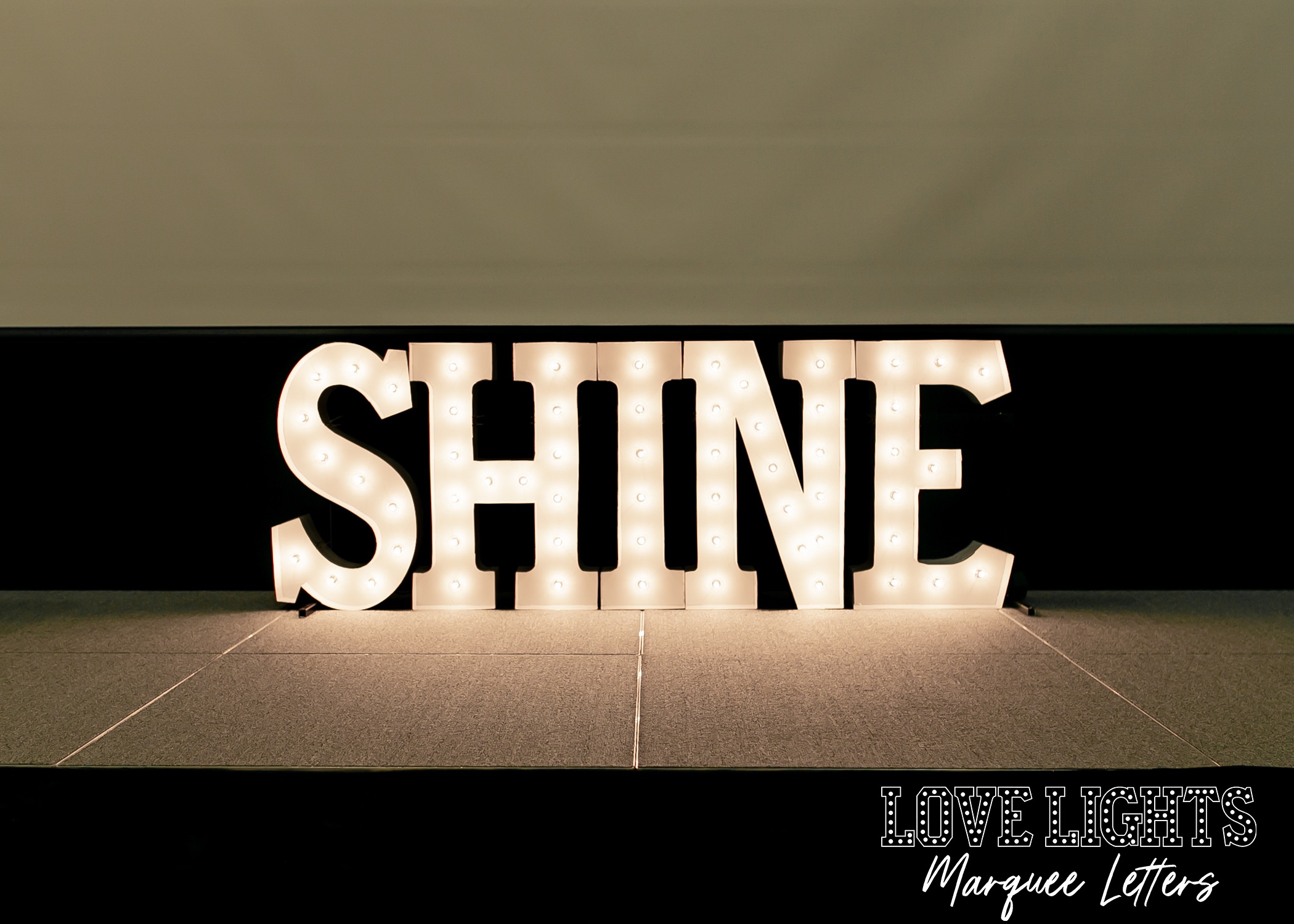 SHINE in lit marquee letters