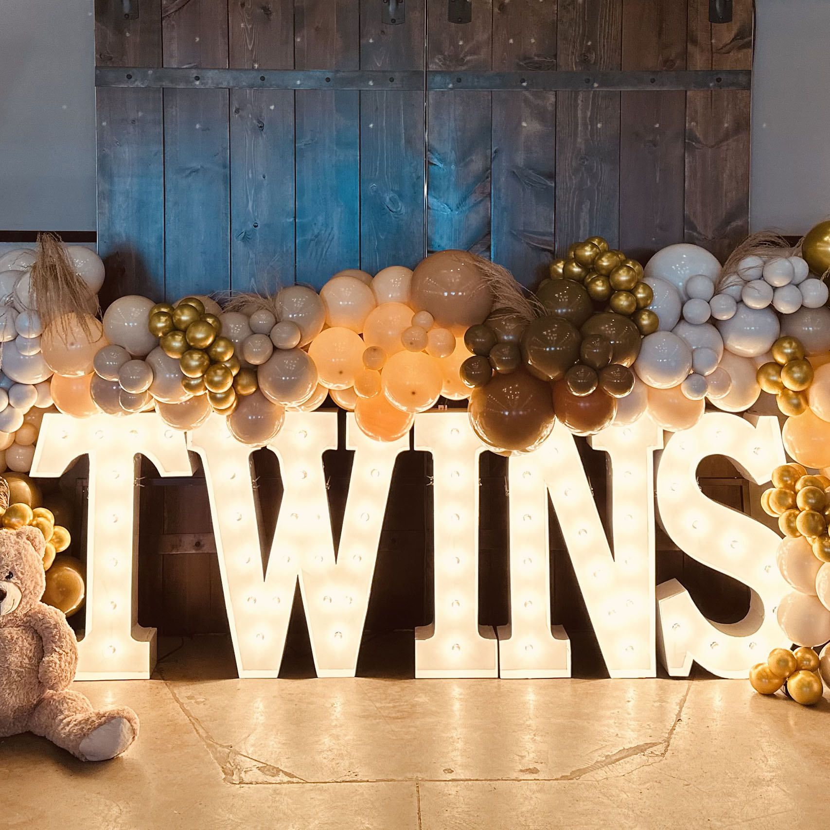Baby Shower Event with Twins in lit up Marquee Leteters with brown, grey, gold, and silver balloons